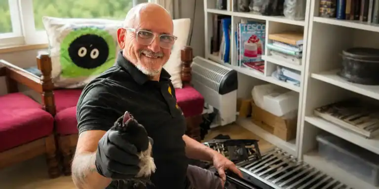 Image shows Tonyt Preston of Flue Check saving a Magpie from a chimney in Warrington