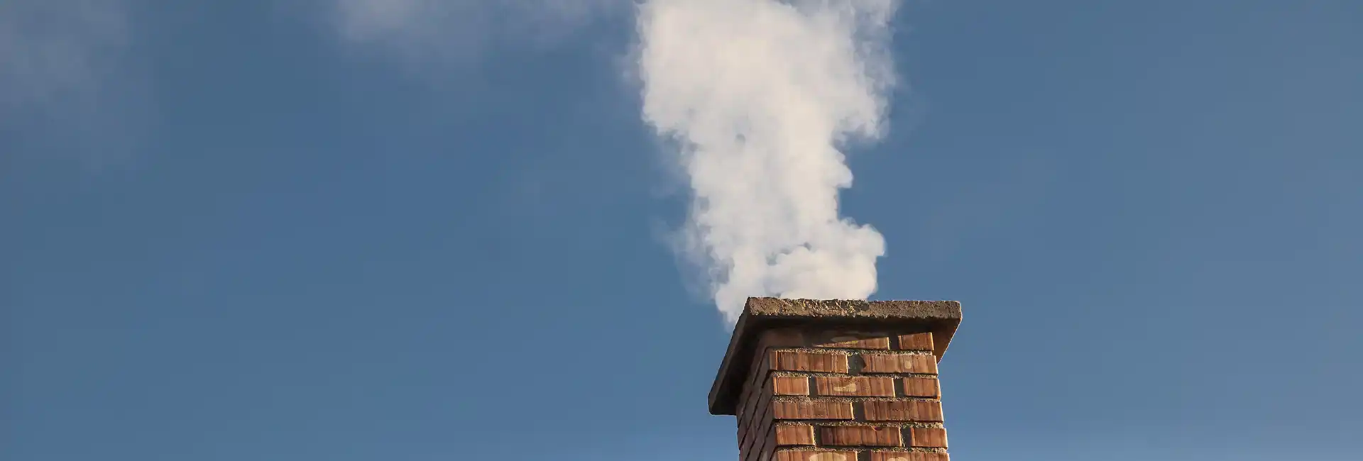 Flue and Chimney smoke testing in Wirral. Image shows chimney with white smoke coming out, used to test chimney and flue leakage